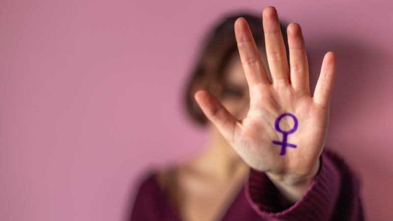 Žena drži podignutu ruku sa simbolom feminizma kao porukom otpora i borbe za prava žena